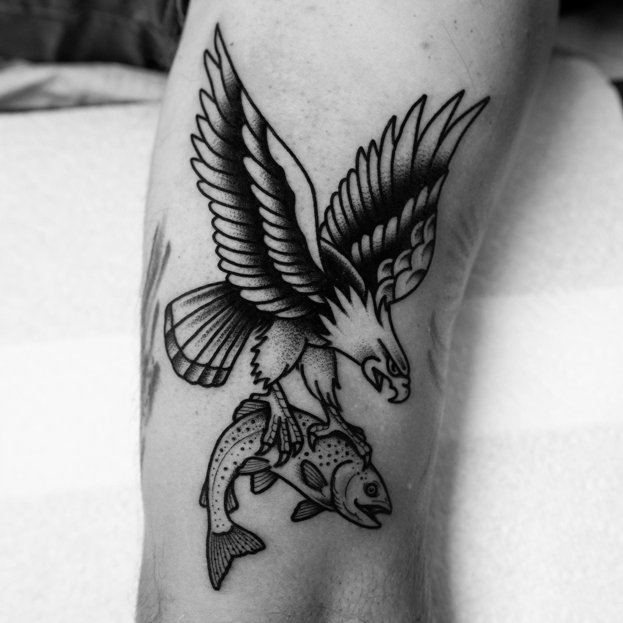 Tatouage traditionnel noir et gris d’un aigle et d’un poisson