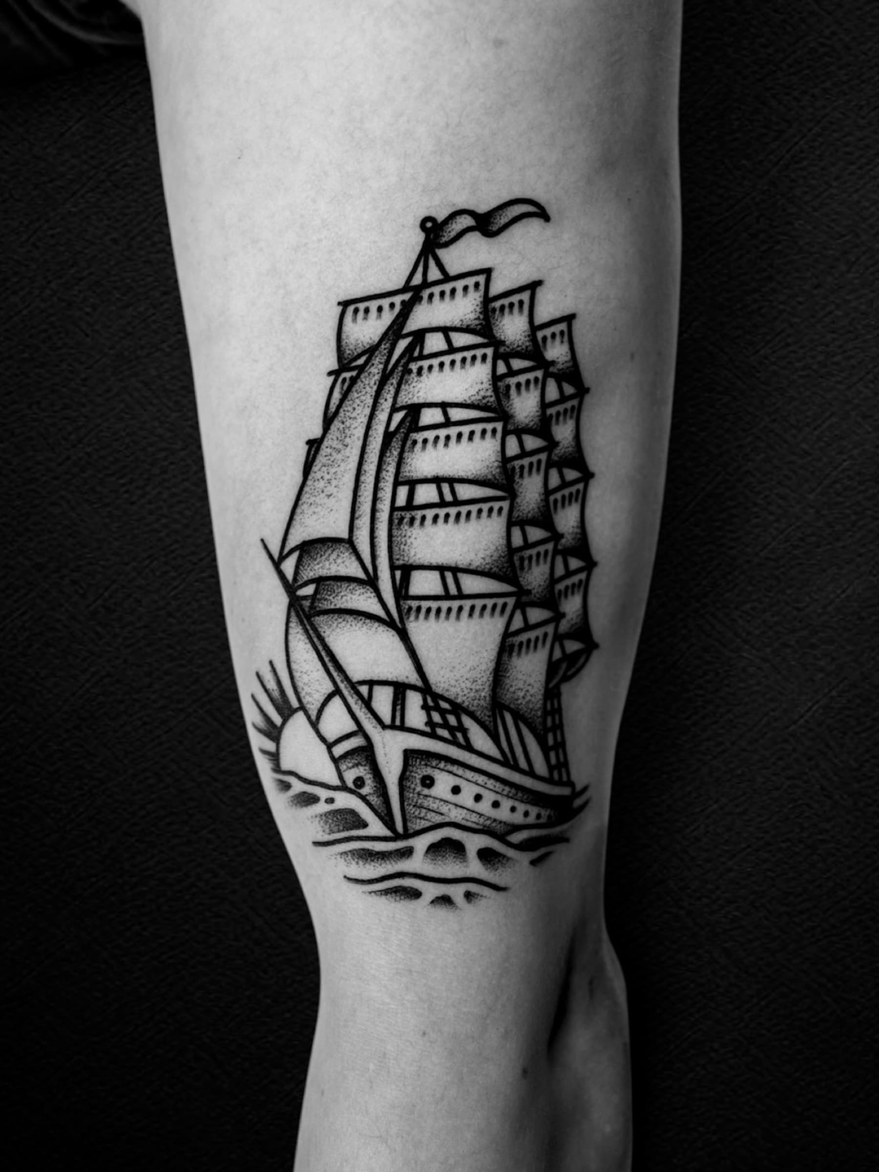 Tatouage noir et gris d’un grand voilier sur l’avant-bras